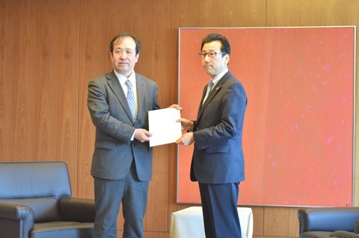 鈴木委員より提言書が渡される様子