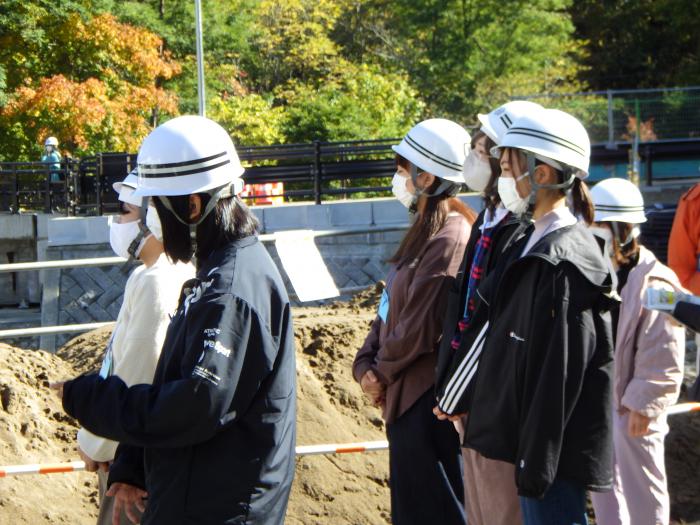 写真:取水堰見学時、説明を熱心に聞く参加学生の様子