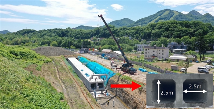 あらかじめ工場で製作したコンクリート製品(取水渠)をクレーンで下ろしてる、令和5年6月撮影の写真を載せています