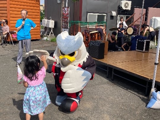 ドーレくんが子供とハイタッチをしている写真