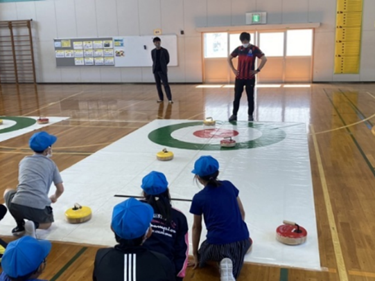子供がフロアカーリングをしている写真