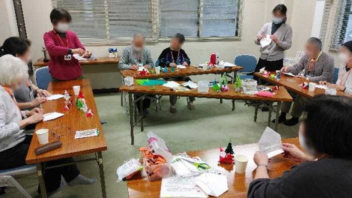 折り紙でクリスマスツリーを作る参加者の様子