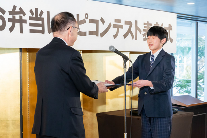 令和6年度札幌市お弁当レシピコンテスト表彰式にて、札幌市長から最優秀賞受賞者へ表彰状を渡している様子