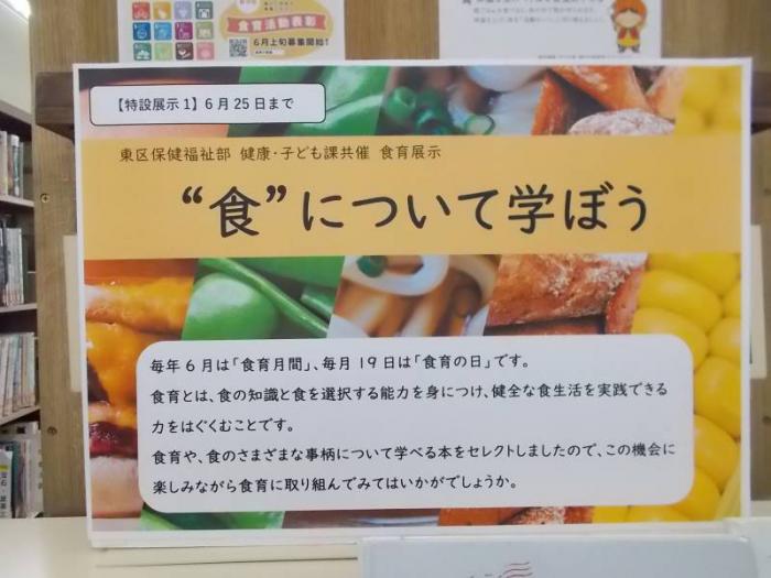 食育展示の看板の写真です。色とりどりの食材を背景にした看板です。