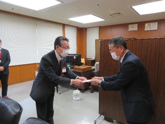 高久手稲区長が緑を語る会福田会長から寄付金を受け取る様子