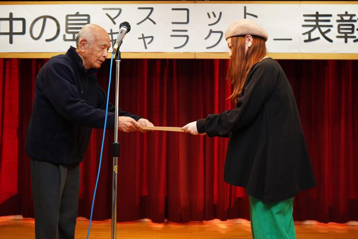 賞状授与の様子（左が本田会長、右が高田さん）