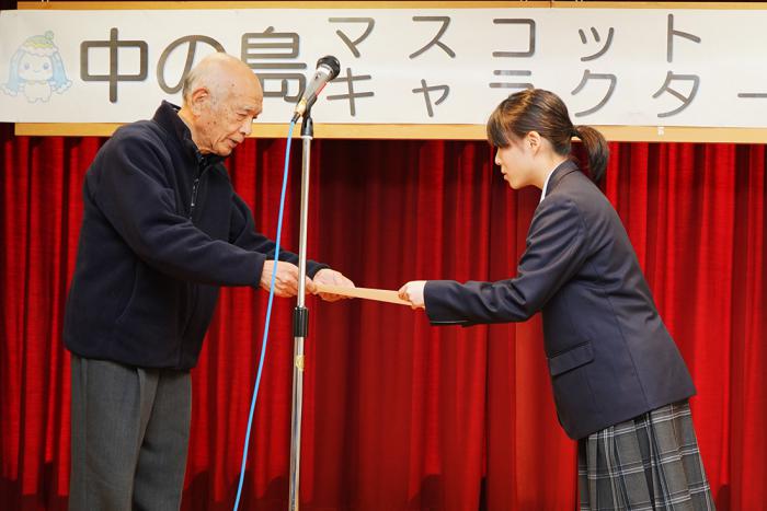 賞状授与の様子(左が本田会長、右が丸山さん)