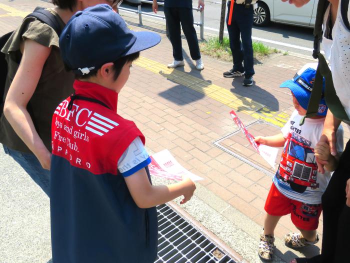 クラブ員が子どもにちらしを配っている様子