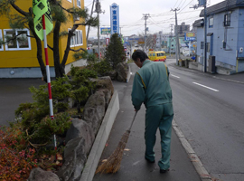 写真:歩道を清掃する社員