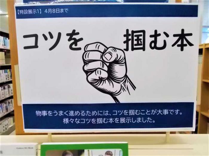 展示の看板写真です。手で何かを掴むようなイラストを添えています。