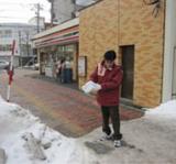 写真:店舗前の歩道の砂まき
